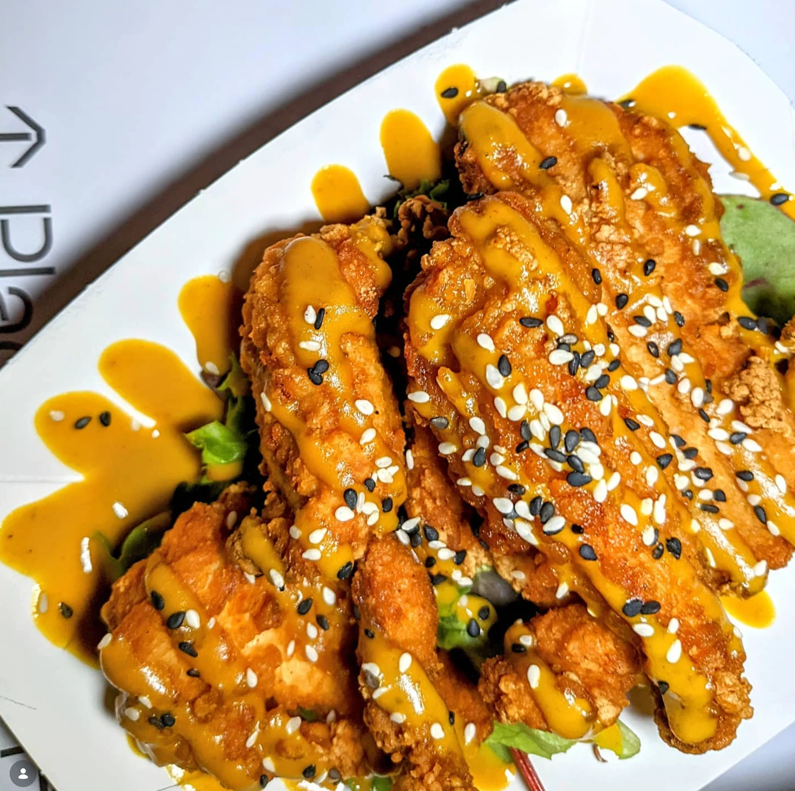 Crispy chicken covered in sauce and scattered with sesame seeds